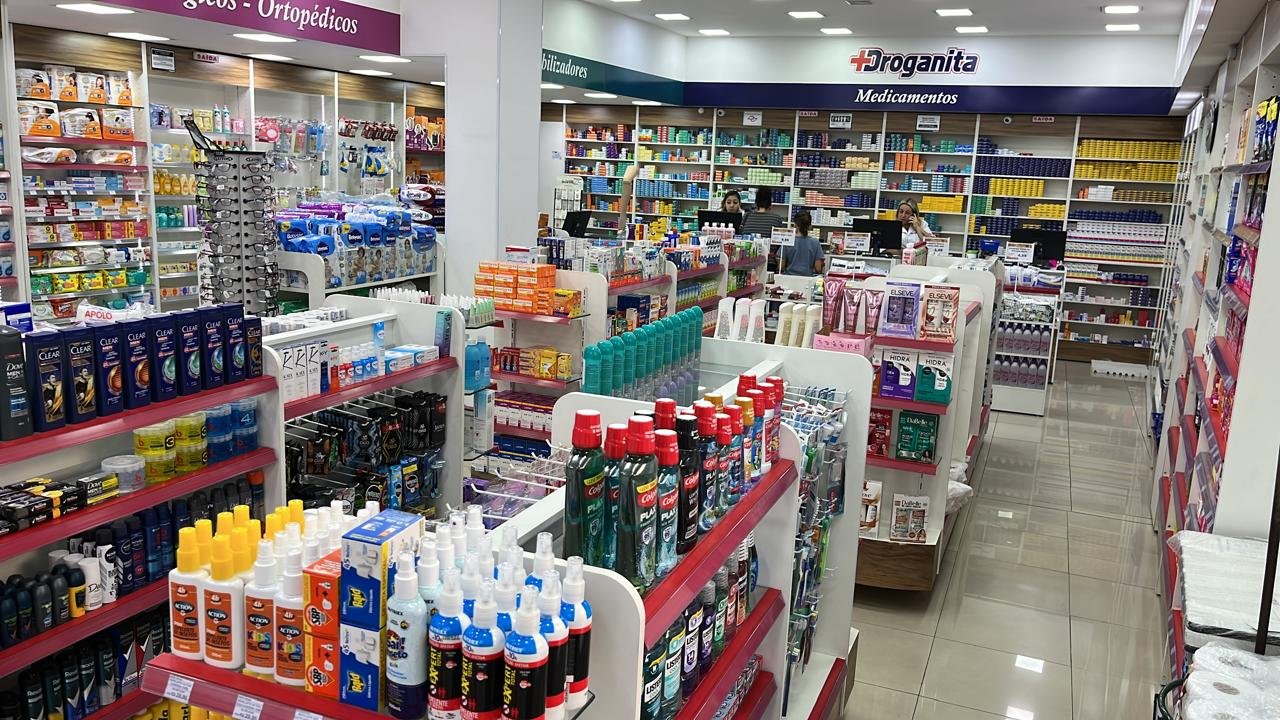Interior da Droganita Popular com prateleiras de medicamentos e higiene